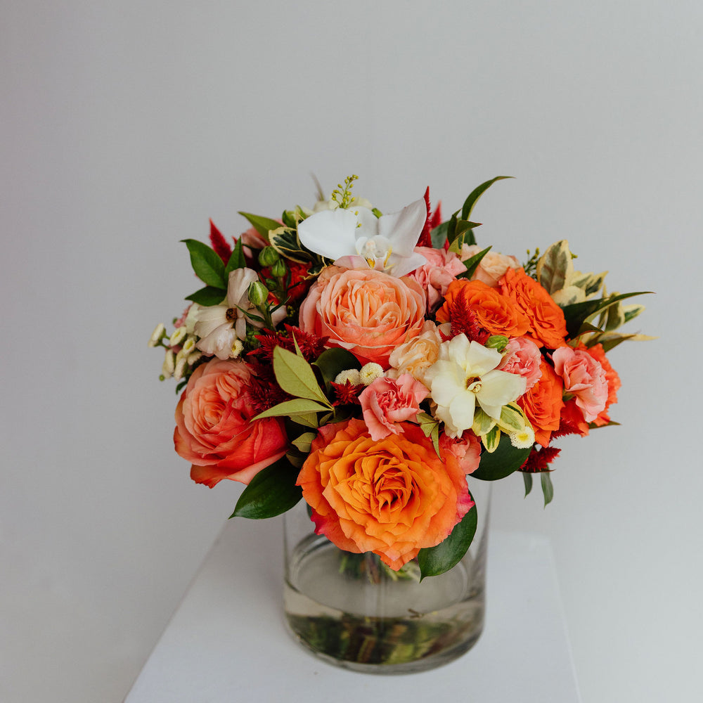 Fall-themed flower arrangement in a glass vase